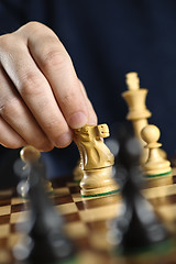 Image showing Hand moving knight on chess board