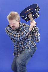 Image showing Man Is Smashing His Guitar On The Floor