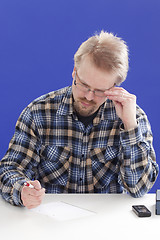 Image showing Man writes notes at his office desk