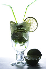 Image showing Mojito cocktail and limes in counter light