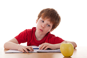 Image showing boy studying and distracted with an apple