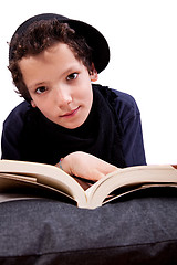 Image showing boy lying on a pillow reading