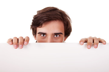 Image showing Young man holding a white board, looking to camera,