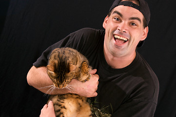 Image showing man with crazed look holding cat