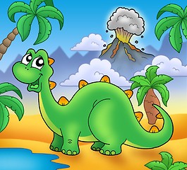Image showing Cute green dinosaur with volcano