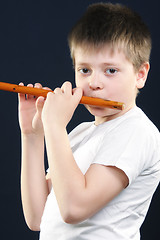 Image showing Boy in white playing flute