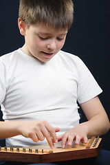 Image showing Boy in white playing gusli