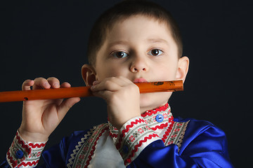 Image showing Little boy playing flute