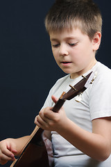 Image showing Boy in white playing balalaika