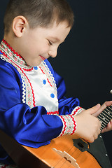 Image showing Little boy playing balalaika