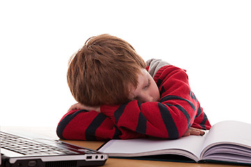 Image showing cute boy on the desk asleep while studying