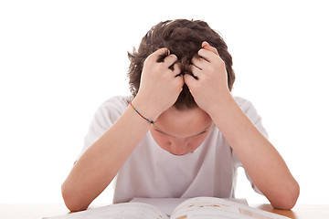 Image showing cute boy on the desk studying and despairing