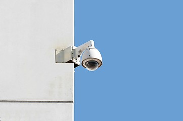 Image showing surveillance camera at a white wall with blue sky background