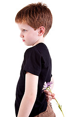 Image showing Young boy hiding flowers behind his back