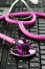 Image showing pink stethoscope on keyboard