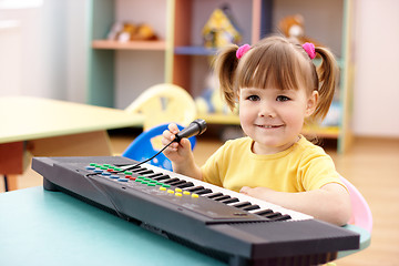 Image showing Girl with electronic piano and microphone