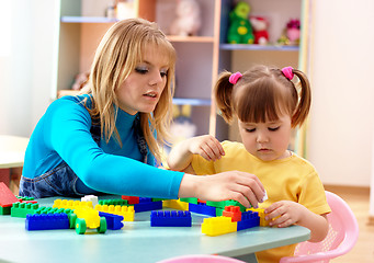 Image showing Teacher and preschooler play with building bricks