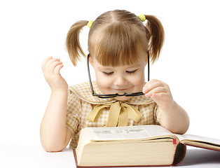 Image showing Happy little girl with book wearing black glasses