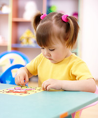 Image showing Little girl coloring a picture in preschool