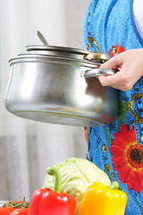 Image showing Hands with pile of pans sideview
