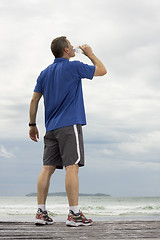 Image showing Mature runner drinking water