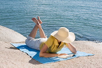 Image showing Woman reading at the sea