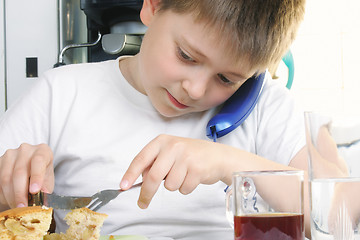 Image showing Boy at breakfast with phone