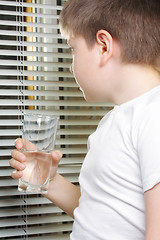 Image showing Boy in white looking to window