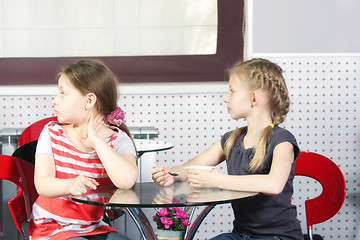 Image showing Girls in cafe looking sideway