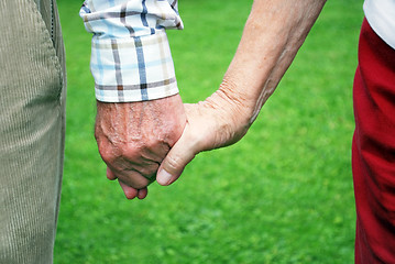 Image showing senior couple holding hands