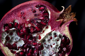 Image showing Sliced Pomegranate with arils on black glass