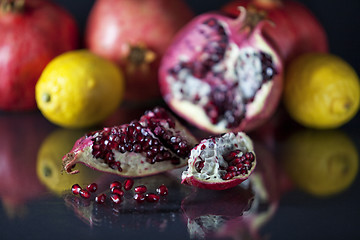 Image showing Sliced Pomegranate with arils on black glass