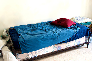 Image showing small used bed in white room