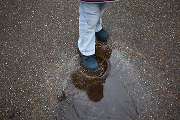 Image showing Child stepping in puddle