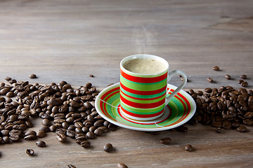 Image showing Coffee in striped cup with beans