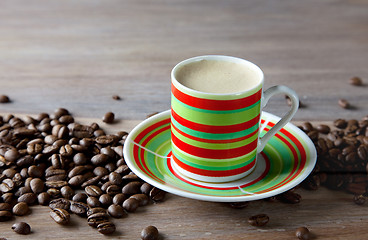 Image showing Coffee in striped cup with beans