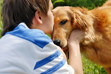 Image showing Boy kissing dog