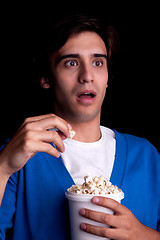 Image showing young man, with popcorn watching