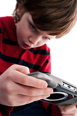 Image showing Young boy playing handheld game console