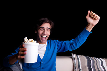 Image showing happy young man, with popcorn watching