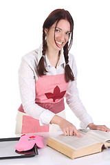 Image showing housewife preparing and reading with a book recipe