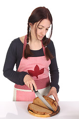 Image showing beautiful housewife cutting bread with knife