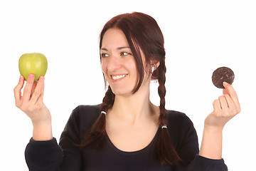 Image showing woman choosing between apple and chocolate cookies