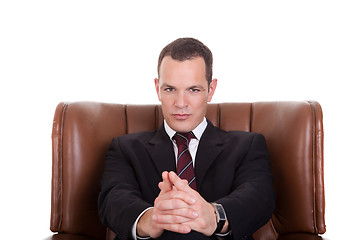 Image showing Businessman seated on a chair, isolated on white background. Studio shot.