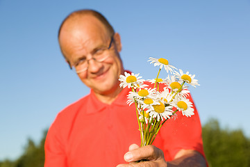 Image showing Middle-aged man giving flowers