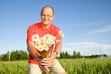 Image showing Middle-aged man giving flowers