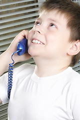 Image showing Smiling boy in white on phone