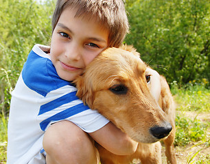 Image showing Boy hugging his dog