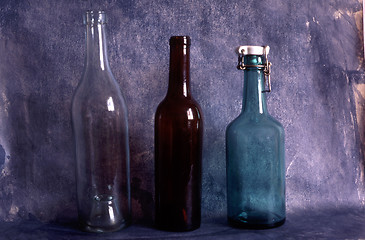 Image showing Three old empty bottles on painted background