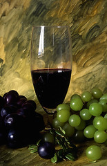 Image showing A glass of wine with grapes on painted background